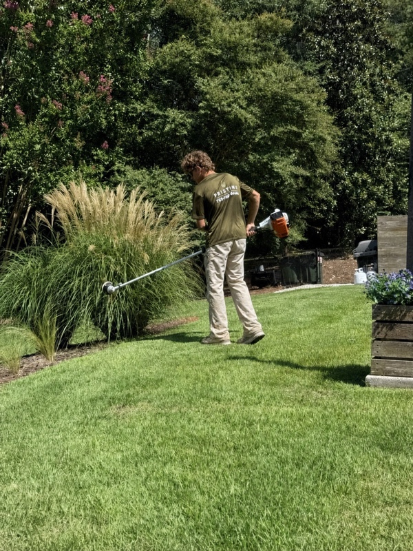 Carrying a string trimmer between landscaped beds