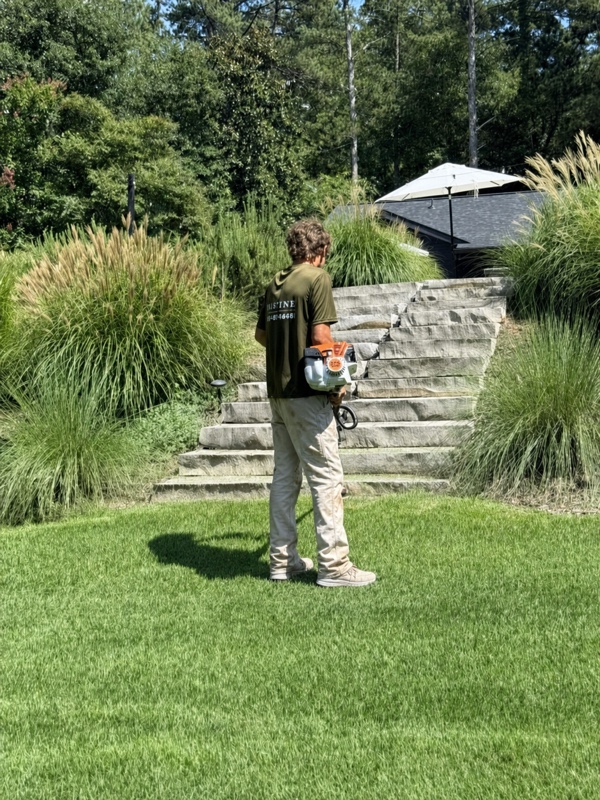 Weed eating along stone steps and ornamental grasses